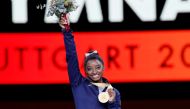 October 13, 2019 Gold medalist Simone Biles of the U.S. celebrates on the podium with her medal and flowers REUTERS/Wolfgang Rattay/File Photo