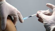 A healthcare worker receives a dose of a Pfizer-BioNTech COVID-19 vaccine at Messe Wien Congress Center, which has been set up as a coronavirus disease vaccination centre, in Vienna, Austria February 7, 2021. REUTERS/Lisi Niesner/File Photo