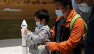 A child holds part of a rocket model at an exhibition featuring the development of China's space exploration on the country's Space Day at China Science and Technology Museum in Beijing, China April 24, 2021. REUTERS/Tingshu Wang/File Photo