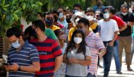 FILE PHOTO: People wearing protective face masks wait to receive a dose of COVISHIELD, a coronavirus disease (COVID-19) vaccine manufactured by Serum Institute of India, outside a vaccination centre in Ahmedabad, India, May 1, 2021. REUTERS/Amit Dave/File