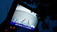 A screen broadcasts a CCTV state media news bulletin, showing an image of Mars taken by Chinese Mars rover Zhurong as part of the Tianwen-1 mission, in Beijing, China, May 19, 2021. Reuters/Thomas Peter 