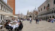 FILE PHOTO: People sit at outdoor tables at St. Mark's Square as Italy lifts quarantine restrictions for travellers arriving from European Union countries, Britain and Israel and begins offering COVID-free flights in a bid to revive the tourism industry, 