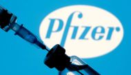 A vial and syringe are seen in front of a displayed Pfizer logo in this illustration taken January 11, 2021. REUTERS/Dado Ruvic/Illustration/File Photo