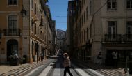 A person wearing a protective mask walks in Lisbon downtown amid the coronavirus disease (COVID-19) pandemic, in Lisbon, Portugal, June 24, 2021. REUTERS/Pedro Nunes