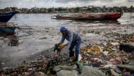 Argie Aguirre, a member of the River Warriors, gathers trash from the heavily polluted Pasig River, in Baseco, Manila, Philippines, June 22, 2021. The 