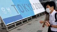 People walk past a sign for the 2020 Tokyo Olympic Games that have been postponed to 2021 due to the coronavirus disease (COVID-19) pandemic, at the IBC/MPC media center at Tokyo Big Sight exhibition center in Tokyo, Japan June 30, 2021. REUTERS/Fabrizio 