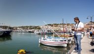 The Jellyfish, a little catamaran operated by remote control, which is capable to clean water by collecting rubbish on the water's surface is seen at work in the port of Cassis, southern France, July 5, 2021. Picture taken July 5, 2021. REUTERS/Noemie Oli