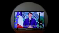 French President Emmanuel Macron is seen on a screen as he addresses the nation about the state of the coronavirus disease (COVID-19) outbreak, in Boulogne Billancourt, France, July 12, 2021. REUTERS/Gonzalo Fuentes
