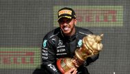 Formula One F1 - British Grand Prix - Silverstone Circuit, Silverstone, Britain - July 18, 2021 Mercedes' Lewis Hamilton celebrates on the podium with the trophy after winning the race REUTERS/Peter Cziborra

