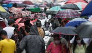 A woman rides a scooter through a crowded market on a rainy day amidst the spread of the coronavirus disease (COVID-19) in Mumbai, India, July 14, 2021. (Reuters/Francis Mascarenhas)