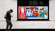 A man walks past a graffiti in support of the NHS, following the outbreak of the coronavirus disease (COVID-19), Marske-by-the-Sea, Britain, April 29, 2020. REUTERS/Lee Smith/Files