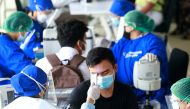  A healthcare worker in personal protective equipment (PPE) checks a man's temperature with a thermal scanner before he receives a dose of the vaccine against the coronavirus disease (COVID-19) at a Mass Rapid Transit (MRT) station, as cases surge in Jaka