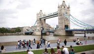 Tower Bridge can be seen as people walk along the River Thames, amid the coronavirus disease (COVID-19) pandemic in London, Britain, July 27, 2021. REUTERS/Henry Nicholls
