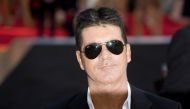 Television mogul Simon Cowell poses for photographers as he arrives for the film 