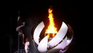 Naomi Osaka of Japan holds the Olympic torch after lighting the cauldron at the Tokyo 2020 Olympics opening ceremony, July 23, 2021. REUTERS/Kai Pfaffenbach/File Photo/File Photo