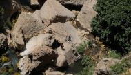 Tourists walk on the rocks of a river under the New Bridge (Puente Nuevo) amid the coronavirus disease (COVID-19) outbreak in Ronda, southern Spain, August 3, 2021. REUTERS/Jon Nazca