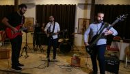 Palestinian accountant Raji El-Jaru and his two cousins, lawyers Saed and Moamin El-Jaru, sing and play the guitar during a rehearsal for the first rock music band Osprey V in Gaza City on August 1, 2021. Reuters/Ibraheem Abu Mustafa