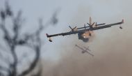 Firefighting airplanes fly as a wildfire continues to rage at Varympompi suburb north of Athens, Greece, August 4, 2021. REUTERS/Giorgos Moutafis