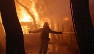 A firefighter reacts as a wildfire burns at Varympompi suburb north of Athens, Greece, August 3, 2021. REUTERS/Giorgos Moutafis/File Photo