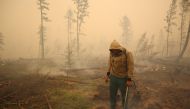 A specialist of the local forest protection service works to extinguish a forest fire near the village of Magaras in the region of Yakutia, Russia July 17, 2021. Picture taken July 17, 2021. REUTERS/Roman Kutukov/File Photo/File Photo