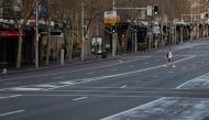 A lone man wearing a protective face mask crosses an empty street during a lockdown to curb the spread of a coronavirus disease (COVID-19) outbreak in Sydney, Australia, July 22, 2021. REUTERS/Loren Elliott
