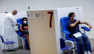 People receive a dose of the Moderna vaccine against the coronavirus disease (COVID-19), a day before the wider Green Pass restrictions, where Italians will need proof of immunity to access an array of services and leisure activities, come into force, at 