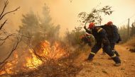 Firefighters and volunteers try to extinguish a wildfire burning in the village of Galatsona, on the island of Evia, Greece, August 9, 2021. REUTERS/Nicolas Economou
