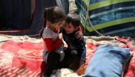 An internally displaced boy from northern provinces, who fled from his home due to the fighting between Taliban and Afghan security forces, is comforted by his sister in a public park that they use as shelter in Kabul, Afghanistan, August 10, 2021. Reuter