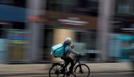 A Deliveroo delivery driver cycles through the centre of Manchester, Britain, March 8, 2021. REUTERS/Phil Noble/File Photo/File Photo