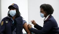 FILE PHOTO: Thelma Modise, a member of the South African Police Service (SAPS) receives a dose of a coronavirus disease (COVID-19) vaccine as part of a vaccine rollout to over 180,000 SAPS members, in the township of Soweto, South Africa July 5, 2021. REU