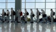 File photo: Passengers wearing protective suits (PPE) line up to board their plane for an international flight at Hong Kong airport amid the spread of the coronavirus disease (COVID-19), China July 9, 2021. Reuters/Thomas Peter/File Photo