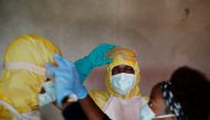 FILE PHOTO: Healthcare workers adjust gear during a funeral of a person who is suspected of dying of Ebola in Beni, North Kivu Province of Democratic Republic of Congo, December 9, 2018. REUTERS/Goran Tomasevic/File Photo

