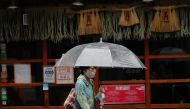 A woman wearing a protective mask, amid the coronavirus disease (COVID-19) outbreak, walks past a temporarily closed restaurant in Fukuoka, Fukuoka Prefecture, Japan, August 17, 2021. REUTERS/Kim Kyung-Hoon