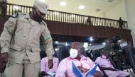 Paul Rusesabagina, portrayed as a hero in a Hollywood movie about Rwanda's 1994 genocide, talks to a prison guard inside the courtroom in Kigali, Rwanda February 17, 2021. Reuters/Clement Uwiringiyimana/File Photo
