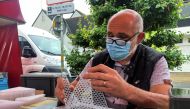 French beekeeper Denis Jaffre, inventor of a trap designed to catch Asian giant hornets, sits in a stall at a market in Pencran, France, August 18, 2021. Reuters/Manuel Ausloos
