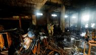 Members of the scout emergency response team, survey amid the burned wreckage, after a fire broke out at a multi-story chemical factory, in Karachi, Pakistan, August 27, 2021. REUTERS/Akhtar Soomro