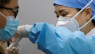 A medical worker prepares to administer a dose of a coronavirus disease (COVID-19) vaccine to a man at a vaccination site, during a government-organized visit, in Beijing, China January 15, 2021. REUTERS/Carlos Garcia Rawlins/File Photo
