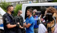 FILE PHOTO: Markus Haintz, a lawyer with the Querdenken group, speaks with police officers during a protest against the government measures to curb the spread of the coronavirus disease (COVID-19), in Berlin, Germany, July 31, 2021. REUTERS/Christian Mang