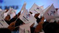 Attendees wave flags with the emblem of the Beijing 2022 Winter Olympic Games at a ceremony unveiling the slogan, in Beijing, China September 17, 2021. REUTERS/Tingshu Wang