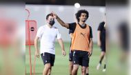 Al Sadd's coach Xavi Hernandez (left) and striker Akram Afif during a practice session yesterday.