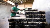 A man arranges newly moulded rubber interlocking tiles manufactured from recycled car tyres at the Freetown waste management recycle factory in Ibadan, Nigeria September 17, 2021. Picture taken September 17, 2021. Reuters/Temilade Adelaja