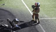 October 8, 2021 Firefighters are seen with a VAR monitor that was burnt in a fire after training Action Images via Reuters/Carl Recine