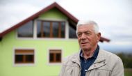 Vojin Kusic poses for a photo in front of his rotating house in Srbac, Bosnia and Herzegovina October 9, 2021. Reuters/Dado Ruvic