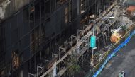 People ride on a vehicle past a damaged residential building following a fire in Kaohsiung, Taiwan October 15, 2021. REUTERS/I-Hwa Cheng TPX IMAGES OF THE DAY