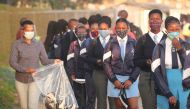 A teacher distributes masks to students as schools begin to reopen after the coronavirus disease (COVID-19) lockdown in Langa township in Cape Town, South Africa June 8, 2020. REUTERS/Mike Hutchings/File Photo