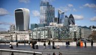 The City of London financial district can be seen as people walk along the south side of the River Thames, amid the coronavirus disease (COVID-19) outbreak in London, Britain, March 19, 2021. REUTERS/Henry Nicholls//File Photo
