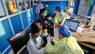 A medical worker administers a dose of a coronavirus disease (COVID-19) vaccine to a child in Huzhou, Zhejiang province, China October 26, 2021. Picture taken October 26, 2021. China Daily via REUTERS