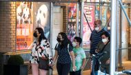 People walk near posters of theatre shows while they wear masks to prevent against the spread of the coronavirus disease (COVID-19), as the highly transmissible Delta variant has led to a surge in infections, in New York City, U.S., July 30, 2021. REUTERS/Eduardo Munoz