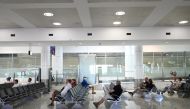 People sit in the arrivals section of the international terminal of Kingsford Smith International Airport the morning after Australia implemented an entry ban on non-citizens and non-residents intended to curb the spread of the coronavirus disease (COVID-19) in Sydney, Australia, March 21, 2020. REUTERS/Loren Elliott/File Photo
