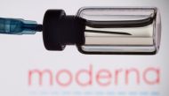 A vial and a syringe are seen in front of a displayed Moderna logo, in this illustration taken, November 27, 2021. REUTERS/Dado Ruvic/Illustration/File Photo